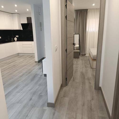 a living room with white walls and a wooden floor at Apartamento Cristina 3 - Playa Arenal Bol in Calpe