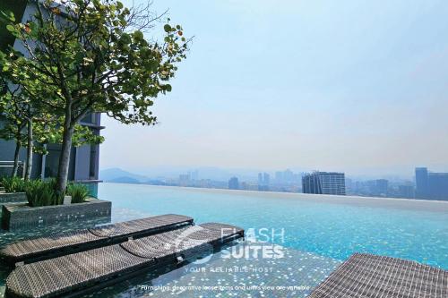 a swimming pool with two benches on top of a building at Expressionz Premium Suites @ KLCC in Kuala Lumpur