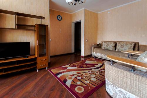 sala de estar con sofá y TV de pantalla plana en Толедо, en Petropavlovsk