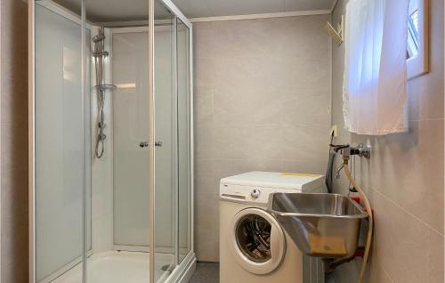 La petite salle de bains est pourvue d'un lave-linge et d'une douche. dans l'établissement Cozy Home In Isfjorden With House A Panoramic View, à Tokle