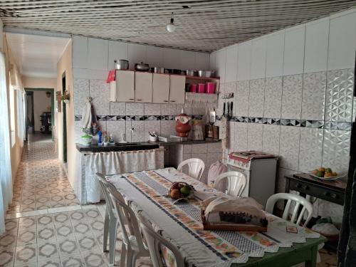 Casa por temporada في غوياس: مطبخ مع طاولة وكراسي في غرفة