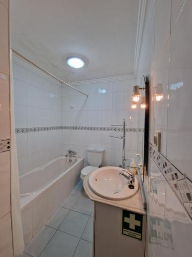 a bathroom with a sink and a tub and a toilet at Furadouro - Apartamento Praia in Ovar