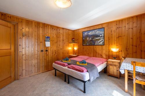 a bedroom with a bed in a wooden wall at Appartamento Elysium -Trepalle in Livigno