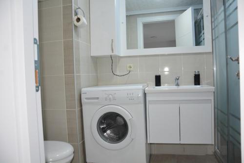 a small bathroom with a washing machine and a sink at Hera Rezidans in Kırac