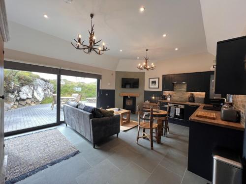 a kitchen and living room with a couch and a table at Raasay Studio Lodge in Arisaig