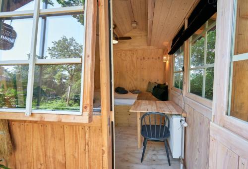 a tiny house with a desk and windows at ZEN-bungalow no 6 met sauna en hottub in Rheezerveen