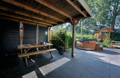 a pavilion with a picnic table and a pool at ZEN-bungalow no 6 met sauna en hottub in Rheezerveen