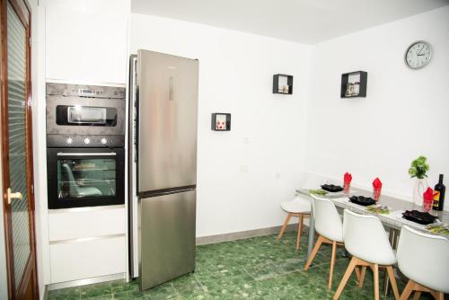 a kitchen with a refrigerator and a table with chairs at Reihenhaus in Alcanar mit Garage in Alcanar