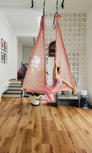 a woman is sitting in a hanging hammock at Loka Home & Yoga in Da Nang