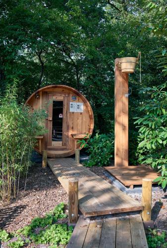 a wooden cabin with a wooden bridge and benches at ZEN-bungalow no 6 met sauna en hottub in Rheezerveen