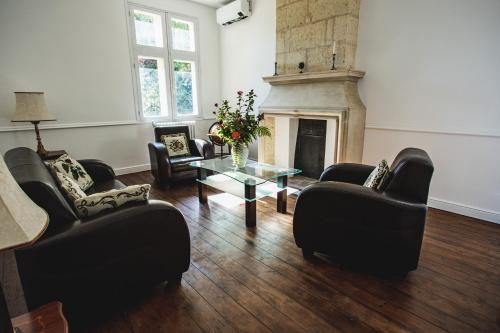 un soggiorno con sedie nere e camino di Chateau La Croix De Millorit a La Reuille