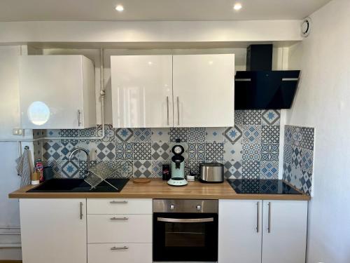 a kitchen with white cabinets and a counter top at Chambre privée dans un appartement partagé in Villeurbanne