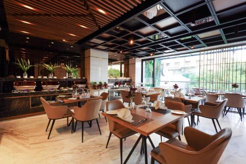 a restaurant with wooden tables and chairs and a bar at Zest Metropole in Colombo