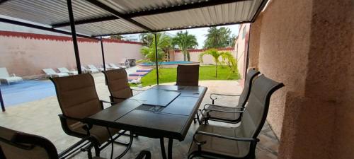 a patio with a table and chairs and a pool at La casa Jorge & Marvin in Cancún