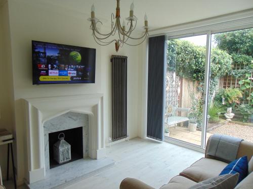 sala de estar con chimenea y TV encima. en Whitstable Lets en Whitstable