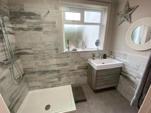 a bathroom with a sink and a shower and a mirror at Whitstable Lets in Whitstable