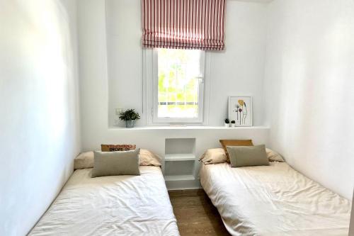 twee bedden in een kleine kamer met een raam bij MARBELLA - ALICATE BEACHFRONT Apartment - 6 in Marbella