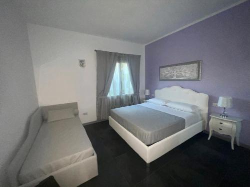 a bedroom with a white bed and a window at Acquamarina Luxury Rooms in Budoni
