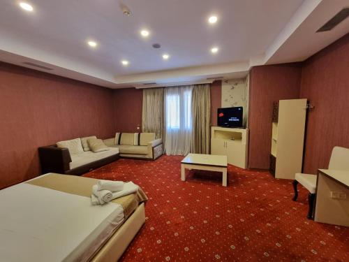 ein Hotelzimmer mit einem Bett und einem Wohnzimmer in der Unterkunft Ariva Hotel and Spa in Baku