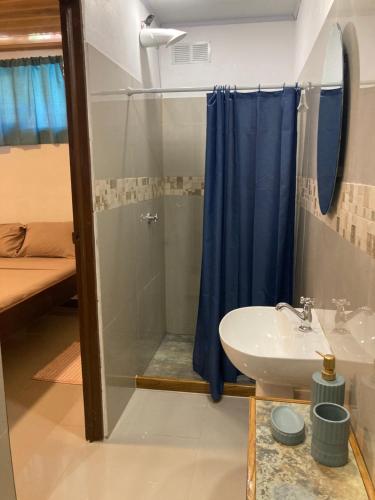 een badkamer met een douche en een wastafel bij TamaHostel & Glamping in Tamarindo