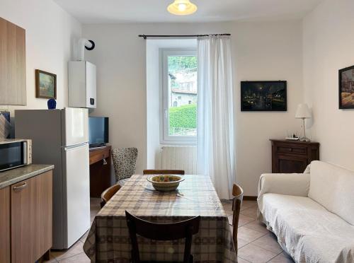 cocina y sala de estar con mesa y sofá en Barzio Village Hideaway, en Barzio