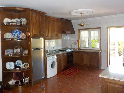 a kitchen with a refrigerator and a dishwasher at Casa de S Bento in Rio Caldo