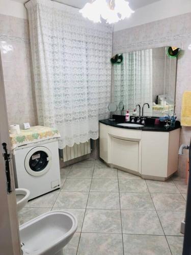 a bathroom with a sink and a washing machine at Villa Fiorella in Costacciaro
