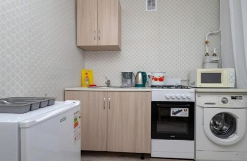 uma cozinha com um fogão, uma máquina de lavar roupa e um micro-ondas em Торонто em Petropavl