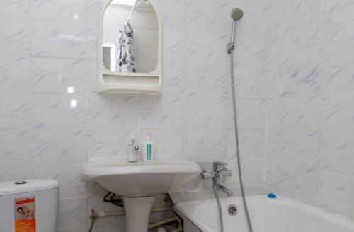 a white bathroom with a sink and a bath tub at Торонто in Petropavlovsk