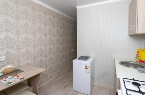 a kitchen with a sink and a white refrigerator at Торонто in Petropavlovsk
