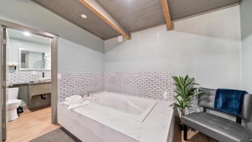 a white bathroom with a tub and a sink at Blue Jay Lodge in South Lake Tahoe