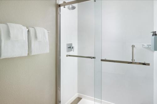 a shower with a glass door in a bathroom at Courtyard by Marriott Fort Lauderdale Plantation in Plantation