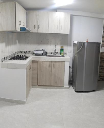uma cozinha com armários brancos e um frigorífico em Apartamento Neiva em Neiva