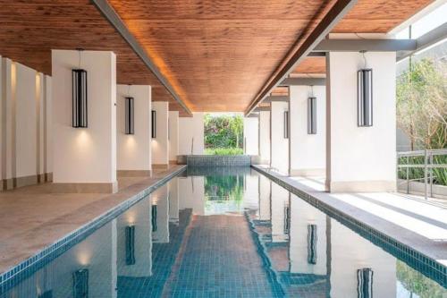 a swimming pool in a house with a wooden ceiling at Studio Moema ao lado do Shopping e metro in São Paulo