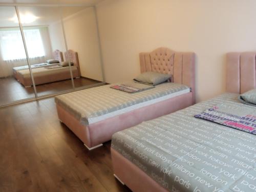 a bedroom with two beds and a mirror in it at Яровиця 2 кімнати in Lutsk