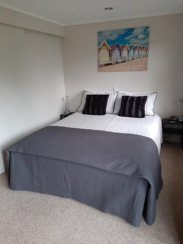 a bedroom with a large bed and a painting on the wall at A Sea View B&B in Picton