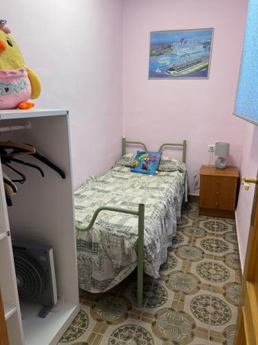 a small bedroom with a bed and a tiled floor at Villa Barby in Lliria