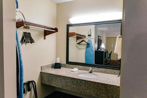 a bathroom with a sink and a large mirror at Motel 6 Nacogdoches, TX in Nacogdoches