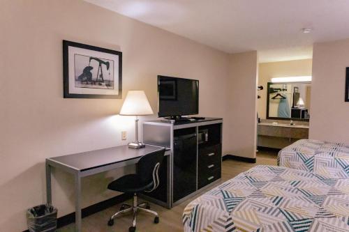a hotel room with a desk and a bed and a bedroom at Motel 6 Nacogdoches, TX in Nacogdoches