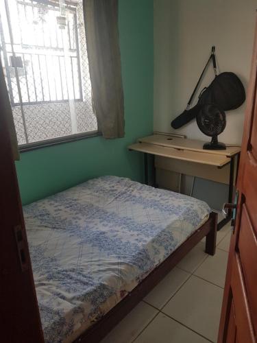 a bedroom with a bed and a desk with a lamp at Quarto com cama de casal na Batista Campos in Belém