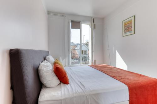 a white bedroom with a bed and a window at Countryside in Paris 14 - Lovely and Calm 1bd Flat in Paris