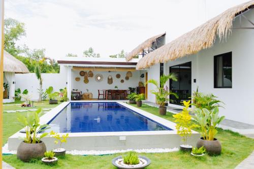 a villa with a swimming pool in front of a house at Panglao Lofts in Panglao