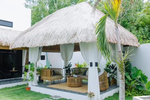 ein Haus mit einem Strohdach und einer Terrasse in der Unterkunft Panglao Lofts in Panglao