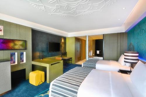 a hotel room with a bed and a desk at W Muscat in Muscat