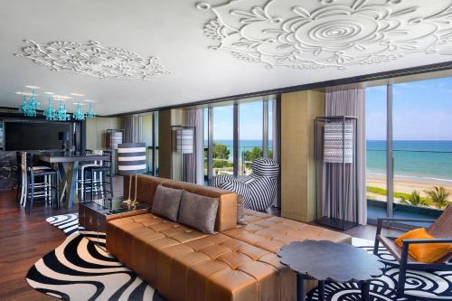 a living room with a couch and a view of the ocean at W Muscat in Muscat