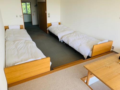 3 camas están alineadas en una habitación en Starry Sky and Sea of Clouds Hotel Terrace Resort - Vacation STAY 75145v en Takeda