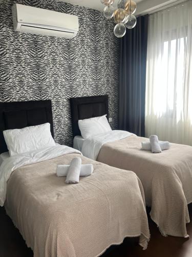 - une chambre avec 2 lits dotés de draps blancs et d'un lustre dans l'établissement konforun adresi, à Istanbul