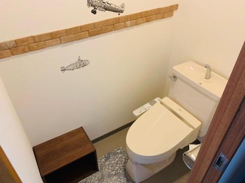 a bathroom with a toilet and a picture of a helicopter on the wall at Starry Sky and Sea of Clouds Hotel Terrace Resort - Vacation STAY 75148v in Takeda
