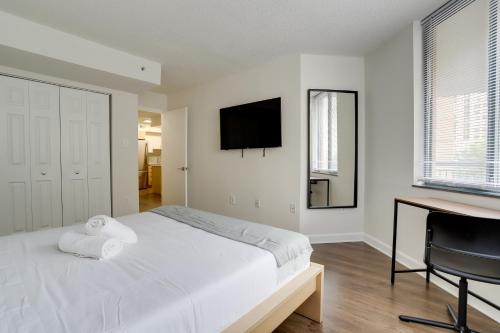 a bedroom with a bed and a desk and a television at Bright & Modern Apartment in Pentagon City in Arlington