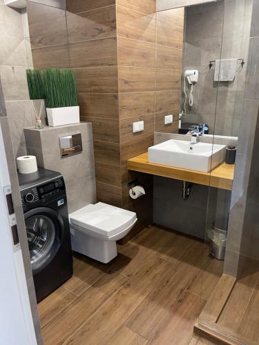 Un baño con lavadora y lavabo. en Sunflower Apartment Old Town, en Cracovia